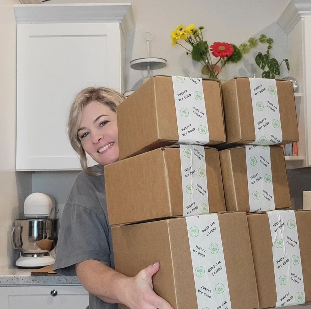 Picture of Amber, founder of Unbound Glo, holding boxes of products to be shipped out